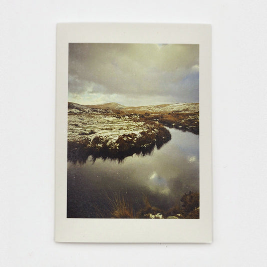 Snow at Taw Marsh Christmas card showing snowy Dartmoor hills and clouds reflected in a still, dark pool