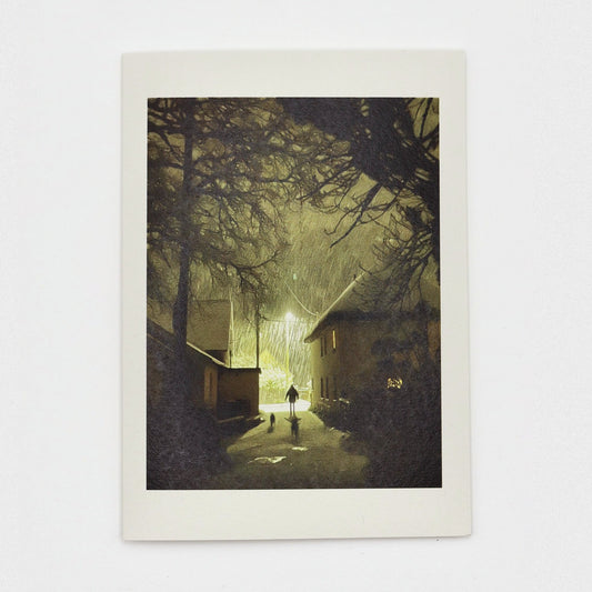 Sticklepath Snow Christmas card showing heavy snow falling at night under a street lamp, a figure and two dogs in the lane