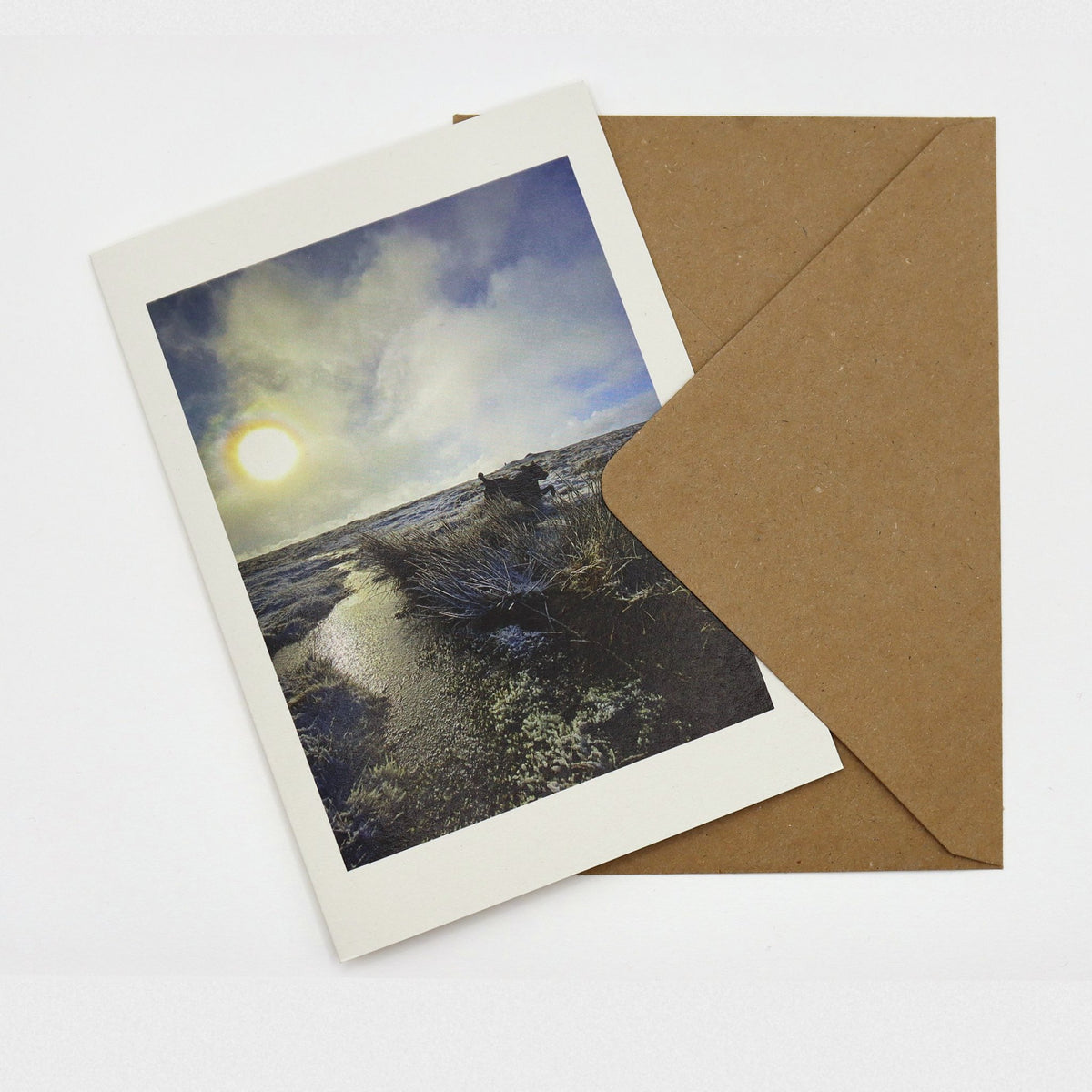 Winter Sun on Cosdon Christmas card showing low sun over frosty Dartmoor moorland with a dog leaping, with kraft envelope